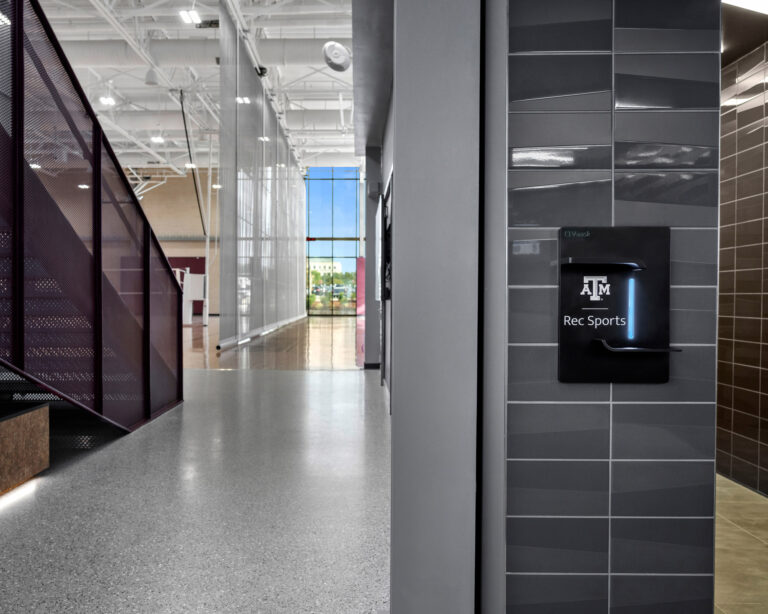A spacious hallway featuring a sizable glass wall inside Texas A&M Rec Center